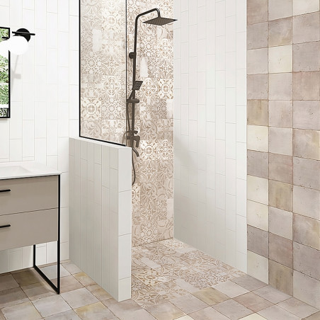 Une zone de douche avec des carreaux complexes à motifs beiges et crème est dotée d'un luminaire de douche noir moderne. Il est 