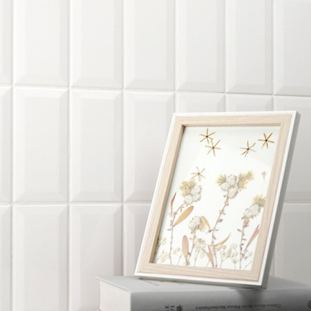 Ein mit Holzrahmen gerahmtes Bild zeigt Blumenkunst neben Sternmotiven und ruht auf zwei gestapelten Büchern vor einer geometris Ein mit Holzrahmen gerahmtes Bild zeigt Blumenkunst neben Sternmotiven und ruht auf zwei gestapelten Büchern vor einer geometris