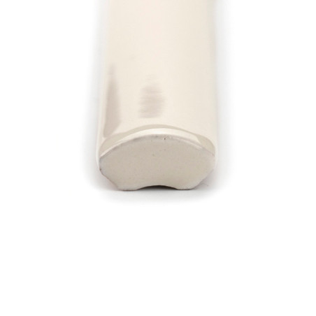 Een glanzende, crèmekleurige keramische siertegel ligt horizontaal en eindigt in een afgeronde, gladde rand. Het is op een effen