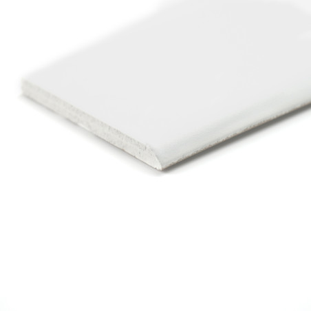 A rectangular white baseboard lies flat and displays a smooth top surface and lightly textured edge on a plain white background. A rectangular white baseboard lies flat and displays a smooth top surface and lightly textured edge on a plain white background.