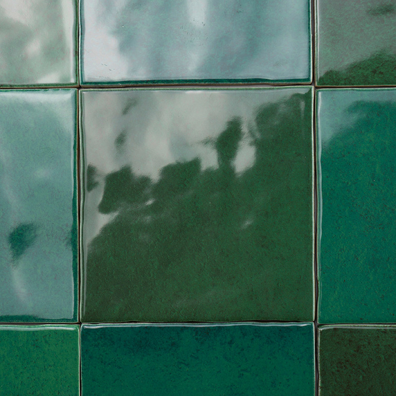 Los azulejos verdes cubren una superficie, reflejando sombras y luces vagas, creando un patrón brillante e irregular dentro de u