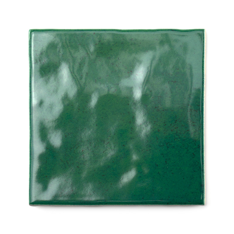 Eine glänzende, smaragdgrüne quadratische Keramikfliese mit leicht ungleichmäßiger Textur, die Licht reflektiert, vor einem schl Eine glänzende, smaragdgrüne quadratische Keramikfliese mit leicht ungleichmäßiger Textur, die Licht reflektiert, vor einem schl