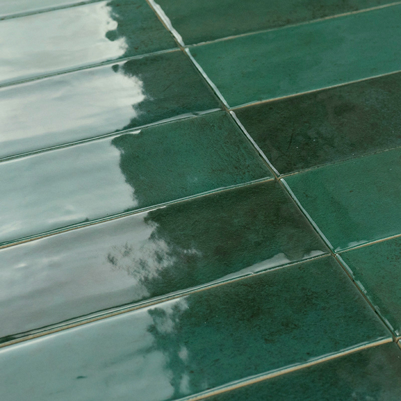 Groene rechthoekige tegels reflecteren licht, waardoor een glanzende glans ontstaat. De subtiele textuur is in een rasterpatroon