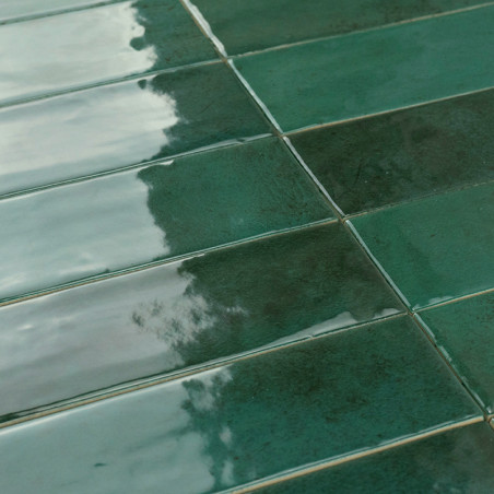 Grüne rechteckige Fliesen reflektieren das Licht und erzeugen einen glänzenden Glanz. Die dezente Textur in einem Gittermuster u