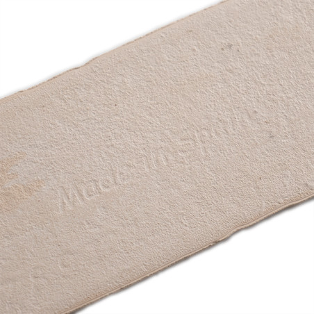 A rectangular beige tile with a textured surface, displaying the text `Made in Spain,` suggesting its origin. positioned on a pl A rectangular beige tile with a textured surface, displaying the text `Made in Spain,` suggesting its origin. positioned on a pl