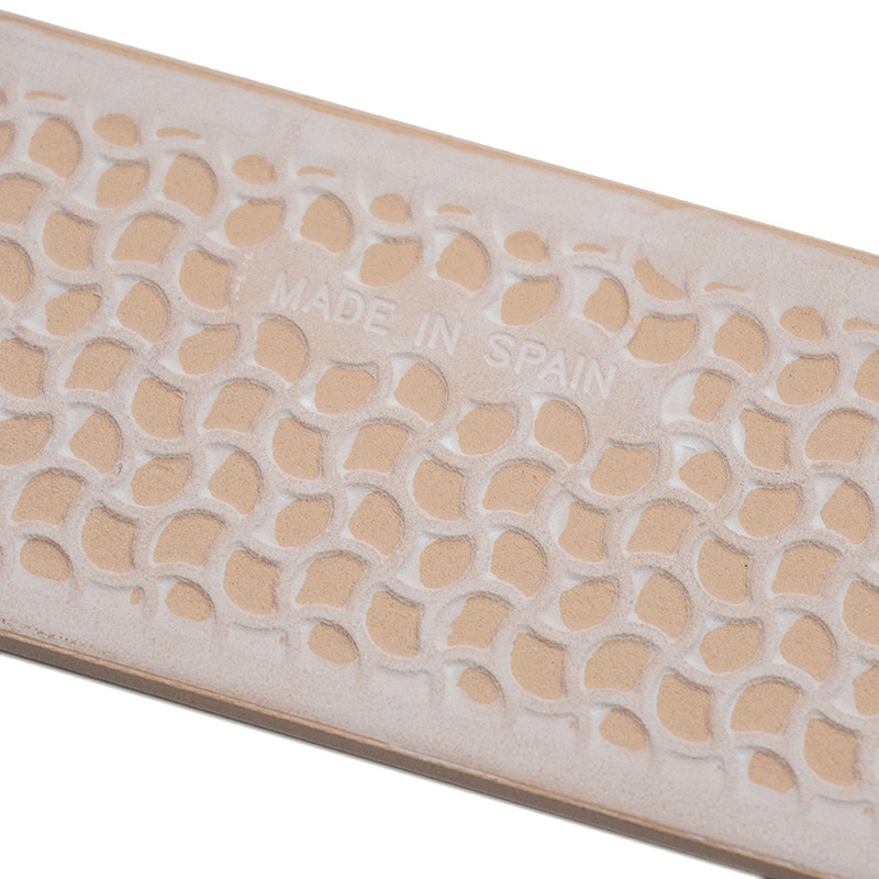 Rechthoekige beige tegel met een verhoogd, gebogen bladachtig patroon en de tekst `MADE IN SPAIN` in reliëf in het midden.