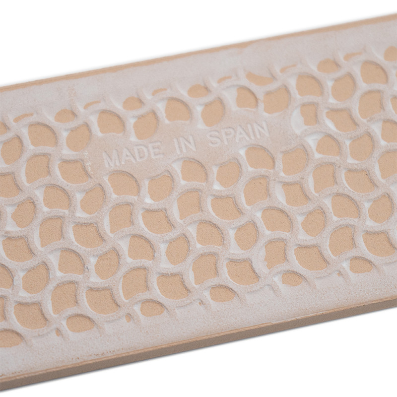 A rectangular tile showcases a repeating, textured geometric pattern. Embossed text reads `MADE IN SPAIN,` with a neutral, earth