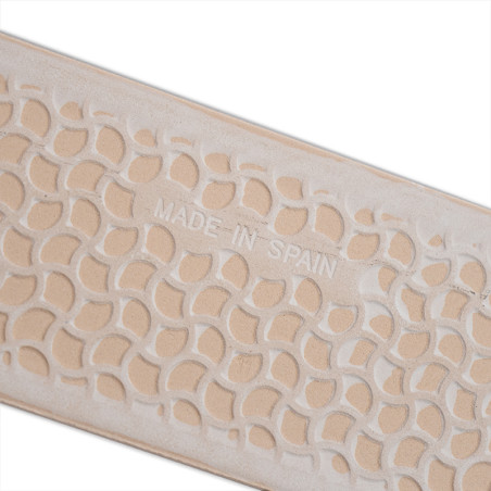 Le carreau beige présente un motif répétitif de formes sculptées en forme de feuilles. « MADE IN SPAIN » est gravé au centre.