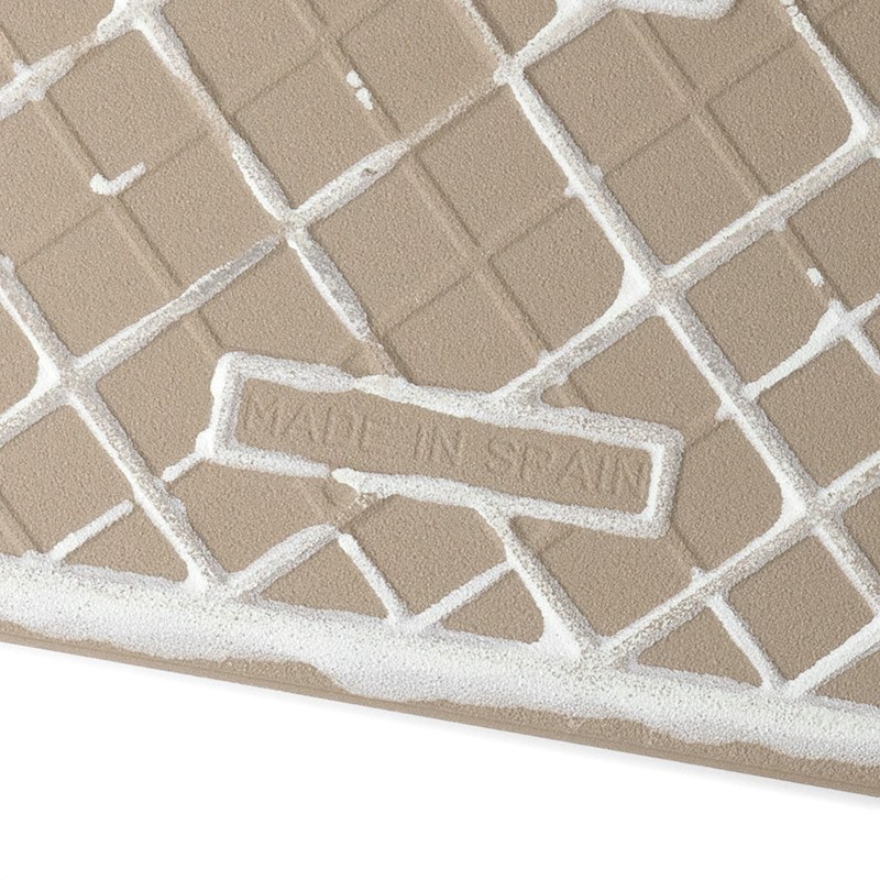 Eine beige Fliese zeigt diagonale Gitterlinien mit weißem Fugenmörtel, der die Lücken füllt. In der Mitte steht „MADE IN SPAIN“ 