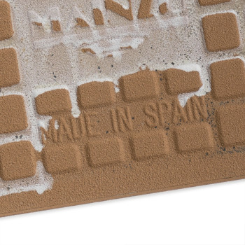 Quadratische, strukturierte Keramikfliesen zeigen die Worte „MADE IN SPAIN“ in eingerückten Buchstaben, teilweise bedeckt von Re