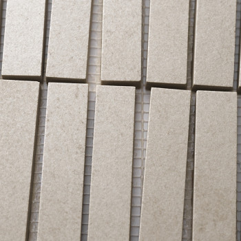 Les carreaux beiges rectangulaires sont disposés en rangées verticales, étroitement alignées sur un support en maille, créant un