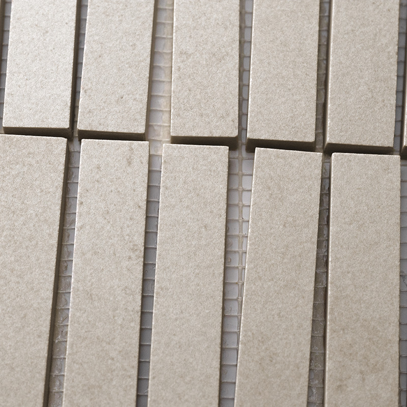 Los azulejos rectangulares de color beige están dispuestos en filas verticales, alineados estrechamente sobre un respaldo de mal