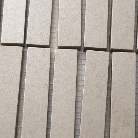 Les carreaux beiges rectangulaires sont disposés en rangées verticales, étroitement alignées sur un support en maille, créant un