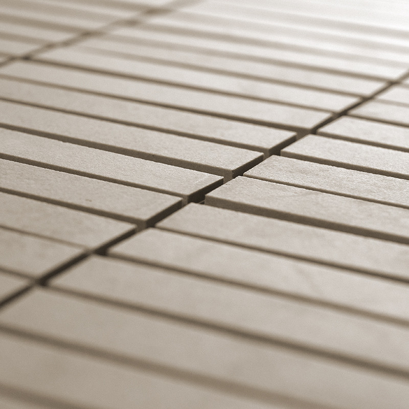 Los azulejos rectangulares de color beige se encuentran en filas paralelas, formando un patrón uniforme en un ambiente espacioso