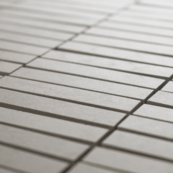 Rechthoekige tegels, uitgelijnd in een rasterpatroon, vormen een glad, doorlopend oppervlak. De lichtgrijze kleur zorgt voor een