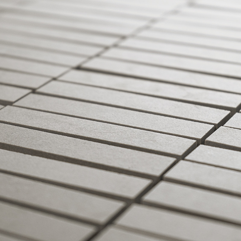 Les carreaux rectangulaires, alignés selon un motif en grille, forment une surface lisse et continue. La couleur gris clair crée
