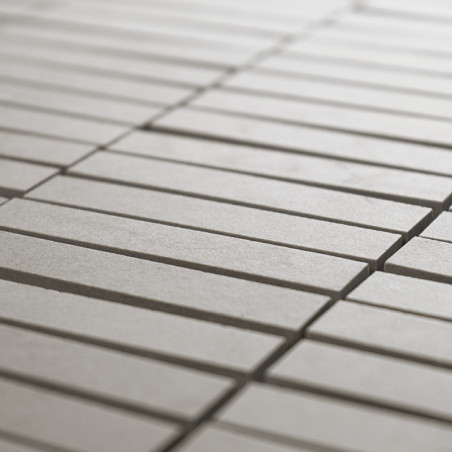 Rechthoekige tegels, uitgelijnd in een rasterpatroon, vormen een glad, doorlopend oppervlak. De lichtgrijze kleur zorgt voor een