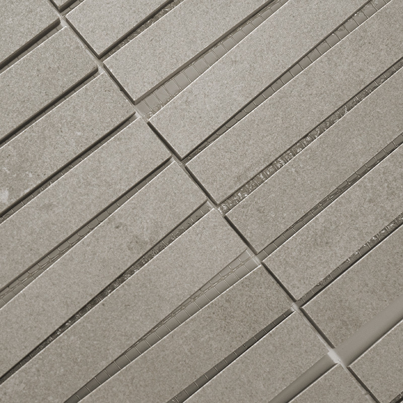Los mosaicos rectangulares de color gris claro están alineados en filas paralelas, creando un patrón de cuadrícula. Están espaci