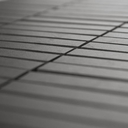 Grijze keramische tegels zijn gerangschikt in uniforme parallelle lijnen, waardoor een rasterpatroon ontstaat. Het perspectief b