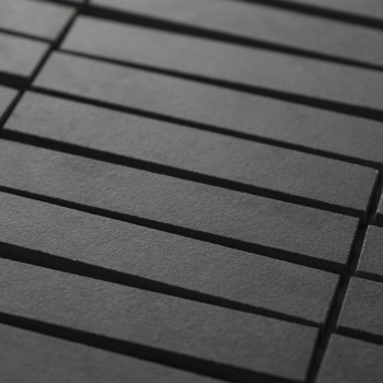Rechthoekige zwarte tegels zijn gerangschikt in een verspringend patroon, waardoor een subtiele geometrische textuur ontstaat. D