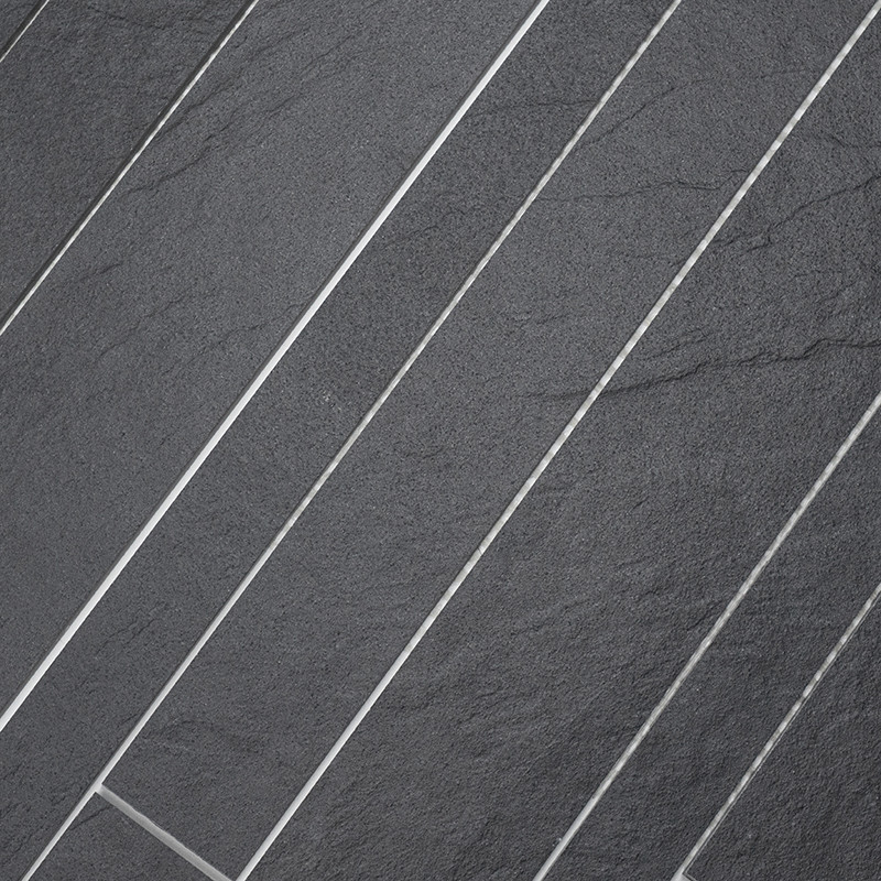 Dark gray rectangular tiles are laid in a diagonal pattern, creating a textured surface with thin, light grout lines.