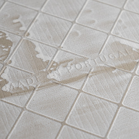 Beige, vierkante tegels hebben een gestructureerd oppervlak met subtiele diagonale patronen. De vage tekst luidt MADE IN PORTUGA Beige, vierkante tegels hebben een gestructureerd oppervlak met subtiele diagonale patronen. De vage tekst luidt MADE IN PORTUGA