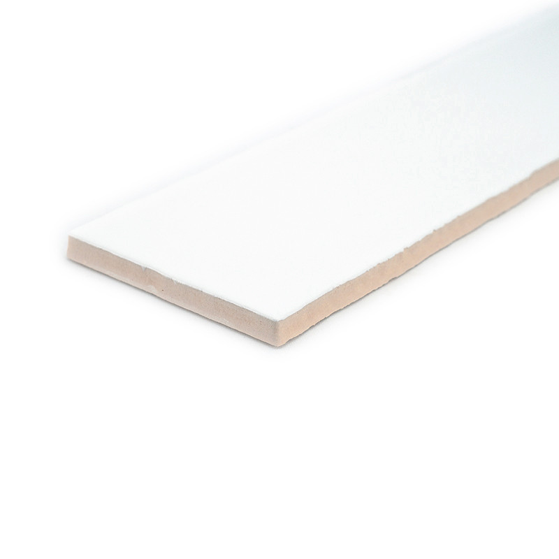 Um ladrilho cerâmico branco retangular repousa sobre um fundo branco, exibindo uma superfície lisa e uma borda levemente bege.