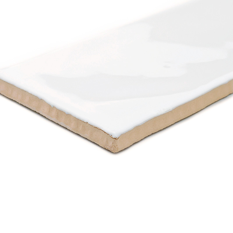 Carreau rectangulaire en céramique à glaçure blanche brillante, posé à plat, montrant son épaisseur et son dessous brun inachevé
