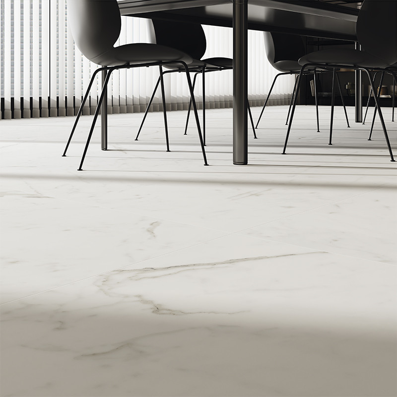 Des carreaux de marbre blanc recouvrent le sol, ajoutant de l'élégance sous une table à manger moderne avec des chaises noires. 