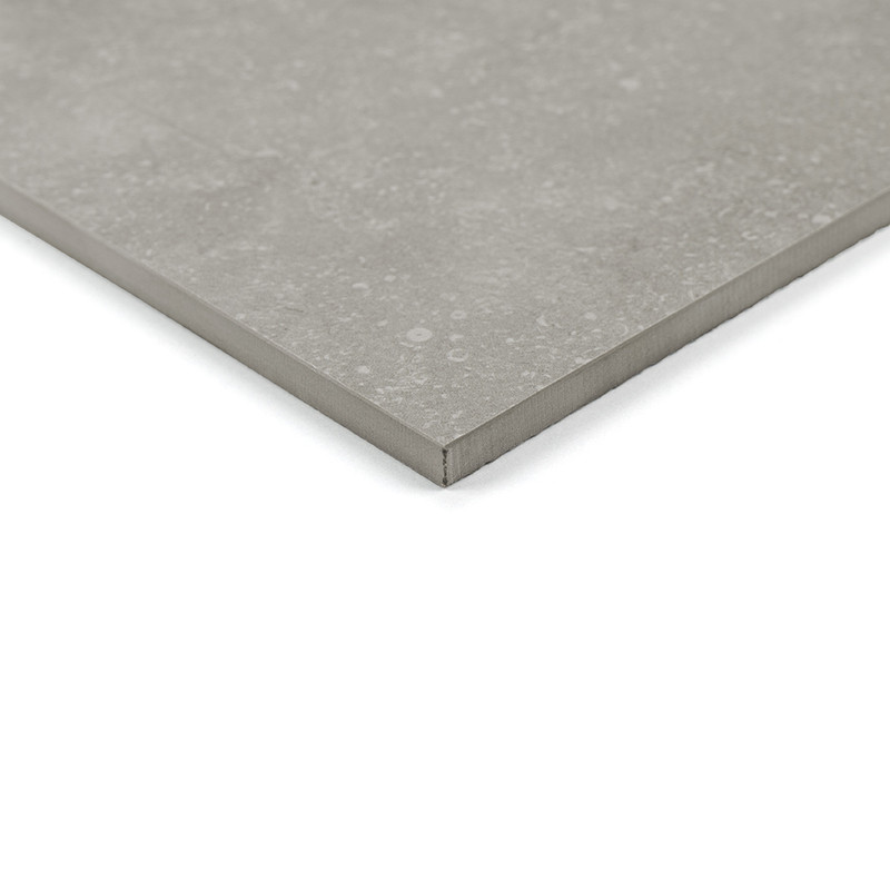 O revestimento cerâmico cinza apresenta um padrão modular com vários formatos retangulares e quadrados. A superfície texturizada