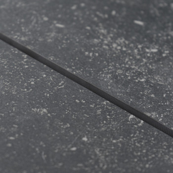 Een getextureerde grijze tegel vertoont subtiele spikkels, waardoor een steenachtig uiterlijk ontstaat, gelegen in een gladde, v