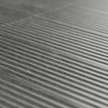 Die strukturierte graue Fliese verfügt über parallele erhabene Rippen, die ein Streifenmuster auf einer glatten, ebenen Oberfläc