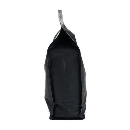 Un sac noir scellé et vertical se dresse sur une surface blanche, semblant structuré et non ouvert. Un sac noir scellé et vertical se dresse sur une surface blanche, semblant structuré et non ouvert.