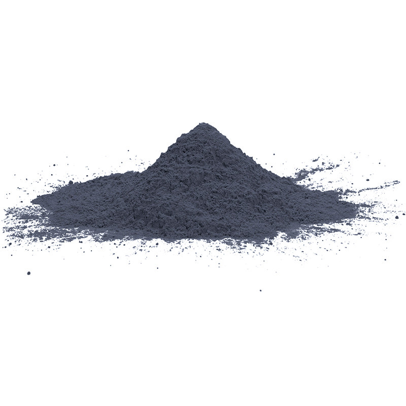 Un monticule de fine poudre grise repose sur une surface lisse et blanche, avec des particules libres dispersées autour.