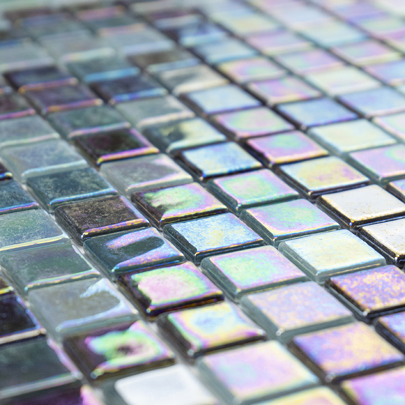 Los azulejos de vidrio iridiscente reflejan la luz, creando un efecto brillante en una superficie plana compuesta de pequeñas pi