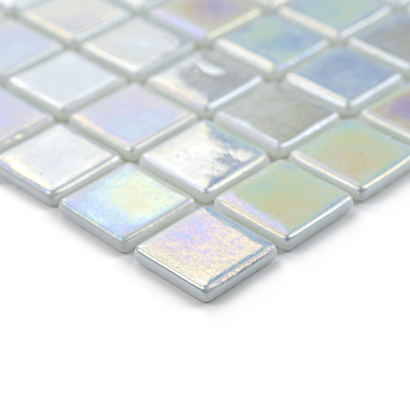 Los azulejos de vidrio iridiscente brillan, dispuestos en forma de cuadrícula, creando un mosaico reflectante y colorido sobre u