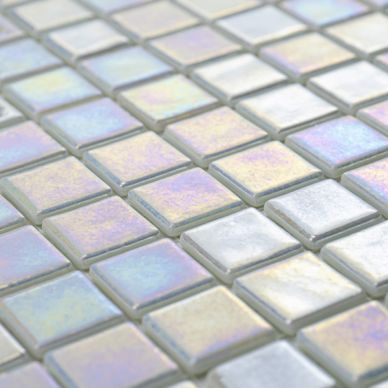 Los azulejos de vidrio cuadrados brillan, reflejan los colores del arco iris en una luz suave y forman una superficie estampada 
