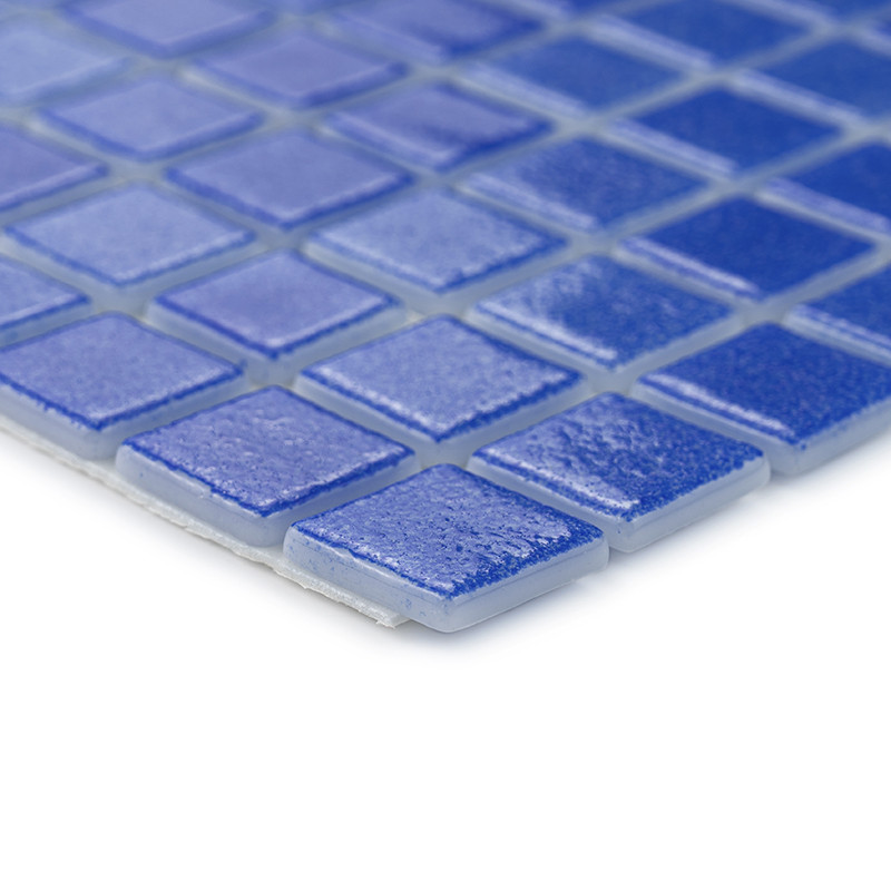 Blauwe vierkante tegels vormen een glasmozaïek dat licht reflecteert en in een rasterpatroon op een vlak oppervlak is gerangschi
