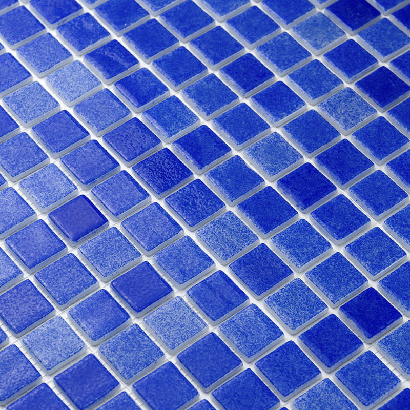 Blaue Glasfliesen bilden ein Mosaikmuster und schaffen eine strukturierte Oberfläche, möglicherweise für eine Wand oder einen Bo