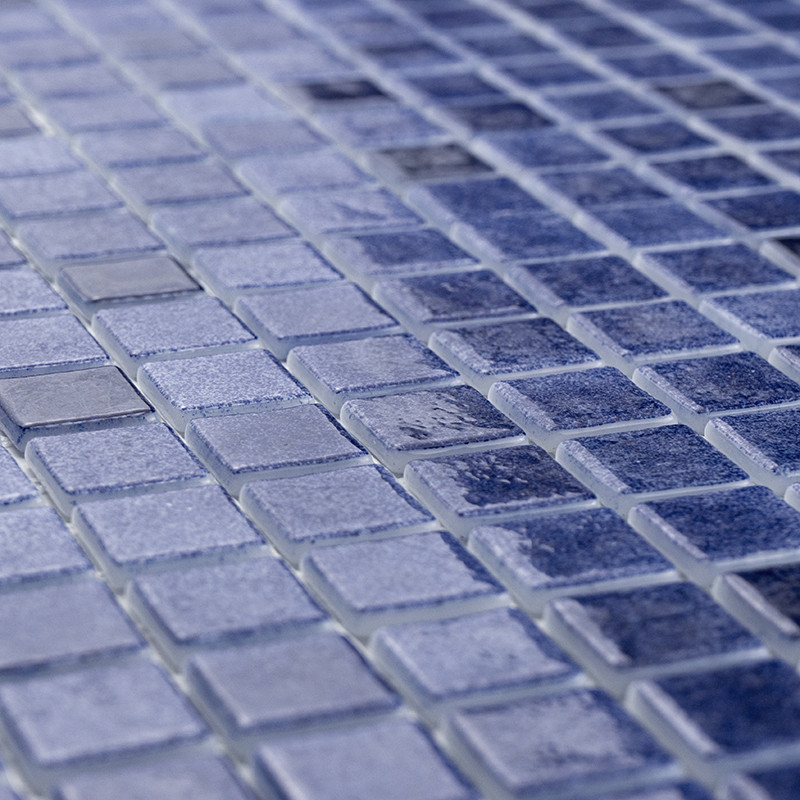 Small blue glass tiles create a shimmering mosaic, reflecting light in various shades, evoking a tranquil aquatic scene.
