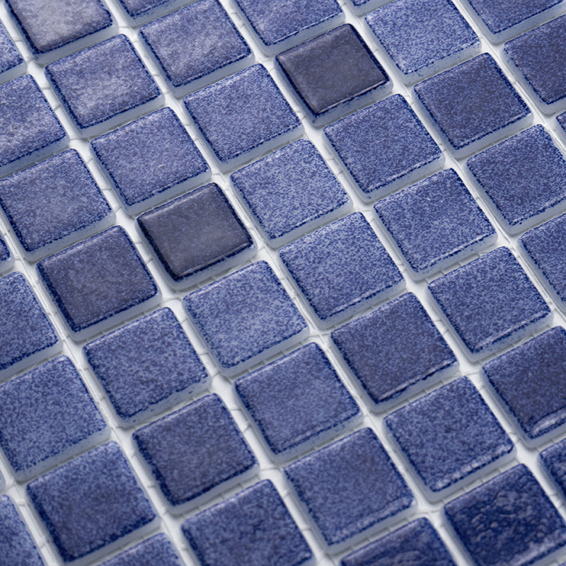 Blaue Glasfliesen bilden ein einheitliches Muster und erzeugen eine strukturierte Oberfläche in einer gitterartigen Mosaikanordn
