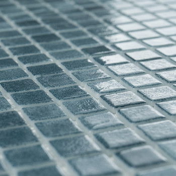 Gleichmäßig angeordnete blaue Glasfliesen, die das Licht reflektieren, erzeugen einen schimmernden Effekt in einem gitterartigen