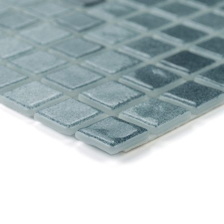 Ladrilhos de vidro quadrados dispostos ordenadamente, refletindo a luz, criam uma superfície texturizada e brilhante em tons sua