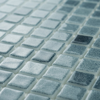 Os mosaicos de vidro exibem vários tons de azul, criando um efeito cintilante à luz ambiente em uma superfície plana e uniforme.