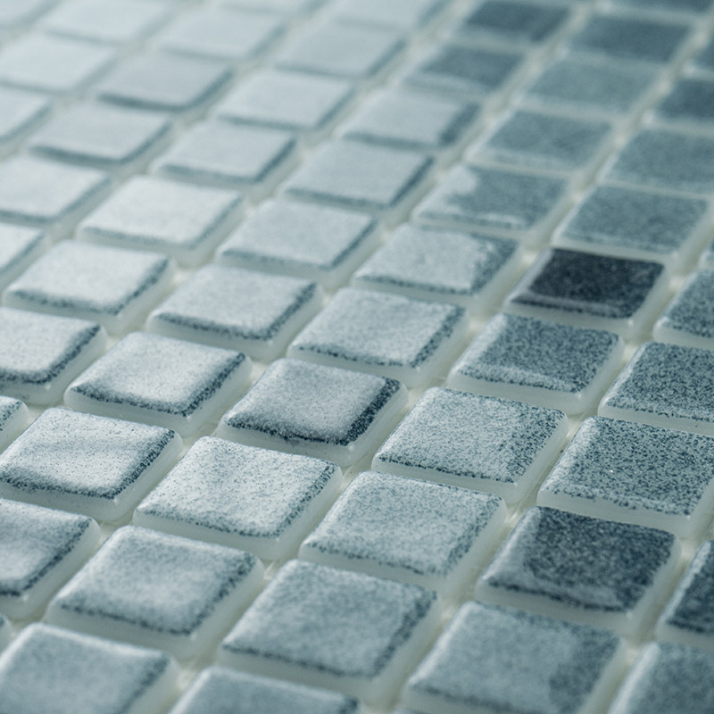 Los mosaicos de vidrio muestran distintos tonos de azul, creando un efecto brillante con luz ambiental sobre una superficie plan