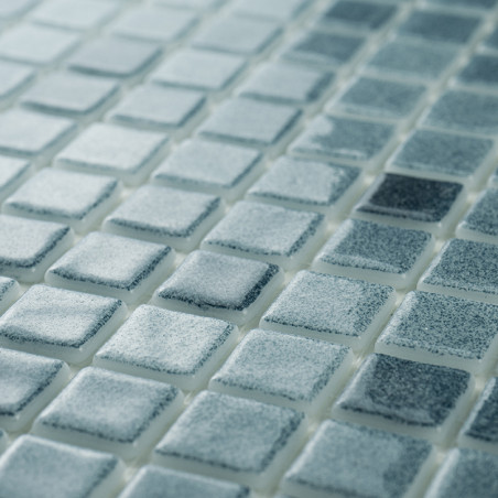 Os mosaicos de vidro exibem vários tons de azul, criando um efeito cintilante à luz ambiente em uma superfície plana e uniforme.