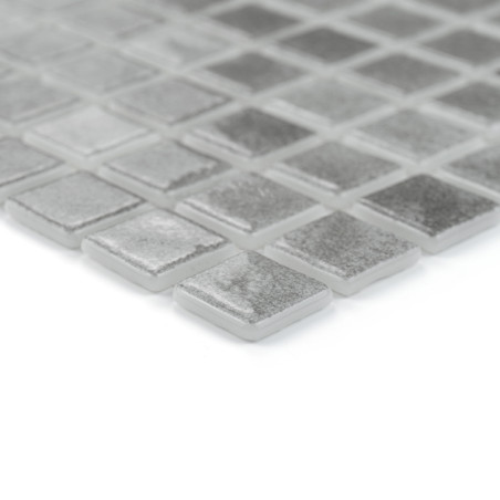 Quadratische Glasfliesen liegen in einem Gittermuster auf und reflektieren das Licht subtil in einem minimalistischen, modernen 