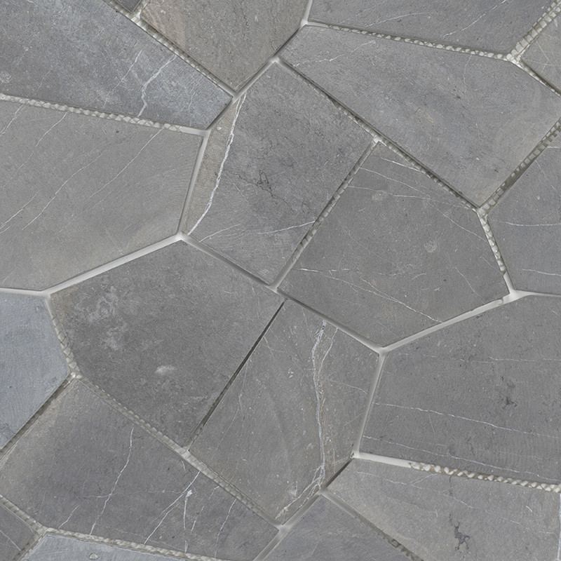 Les carreaux de pierre grise irréguliers forment un motif en mosaïque, étroitement imbriqués, mettant en valeur une surface natu