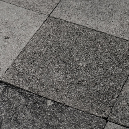 Graue Steinfliesen bilden eine strukturierte, unebene Oberfläche in einem geometrischen Muster und vermitteln eine natürliche, r