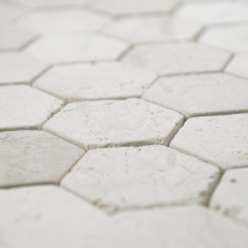 Sechseckige Steinfliesen greifen eng ineinander und bilden eine strukturierte, nahtlose weiße Oberfläche mit einem klaren, geome